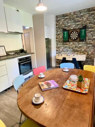 une table en bois dans une cuisine avec une table et des chaises dans l'établissement La Belle Donne maison 6 personnes baby foot PS4 - ventilateurs, à Pontcharra