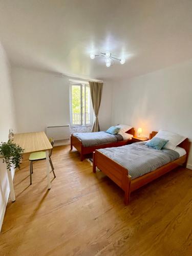 un salon avec deux lits et une table dans l'établissement La Belle Donne maison 6 personnes baby foot PS4 - ventilateurs, à Pontcharra