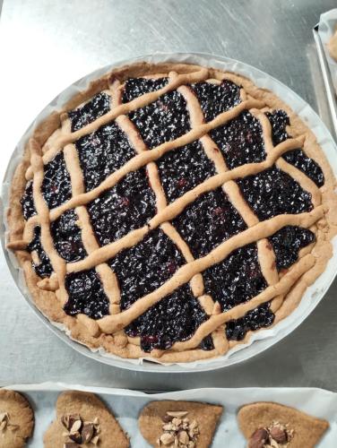 a blackberry pie on a plate next to cookies at Agriturismo Al Marnich in Schignano