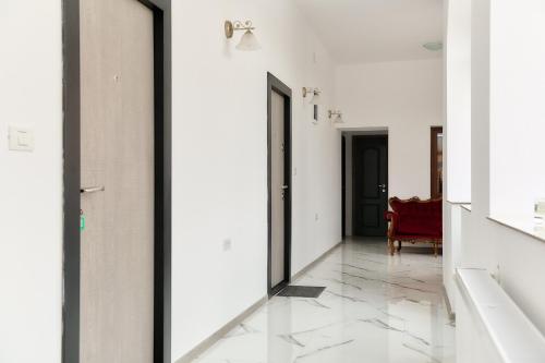 a hallway with two doors and a red chair at Casa Marko in Nădlac