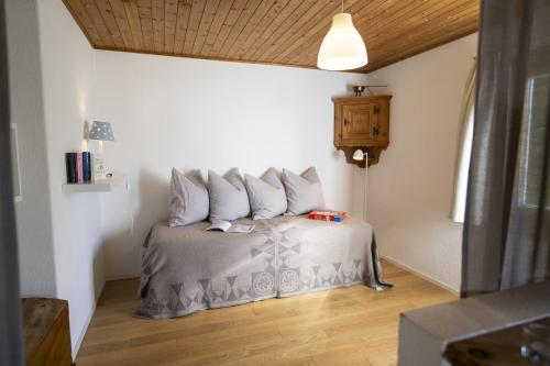 a bedroom with a bed with four pillows on it at Chasa Arquint in Sent