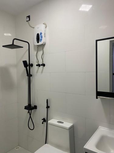 a white bathroom with a toilet and a mirror at Crystal sea inn in Bileffahi