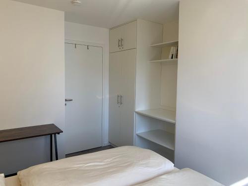 a bedroom with a bed and a desk and shelves at Strandhaus Ahlbeck (100 m vom Strand) in Ahlbeck