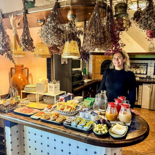 a woman standing in a kitchen with a table of food at Villa Monica B&B in Sorrento