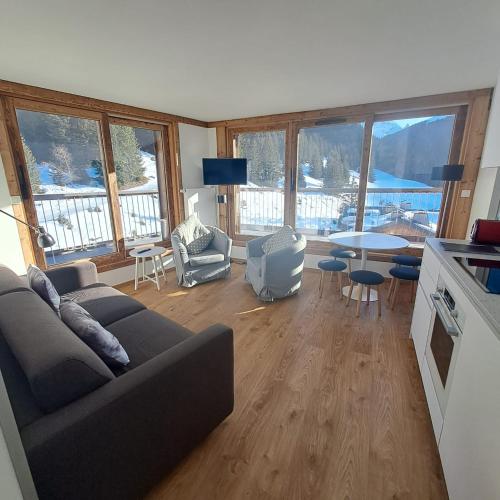 un salon avec un canapé et une table avec des chaises dans l'établissement Croix-Des-Verdon Full renovated - Ski in and out - Courchevel 1650 with covered parking, à Courchevel