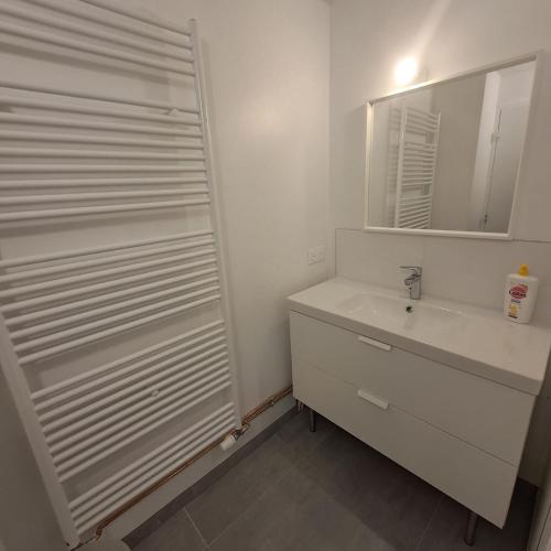 une salle de bain blanche avec un lavabo et un miroir dans l'établissement Croix-Des-Verdon Full renovated - Ski in and out - Courchevel 1650 with covered parking, à Courchevel