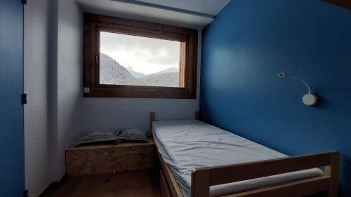 une petite pièce avec un lit et une fenêtre dans l'établissement Croix-Des-Verdon Full renovated - Ski in and out - Courchevel 1650 with covered parking, à Courchevel