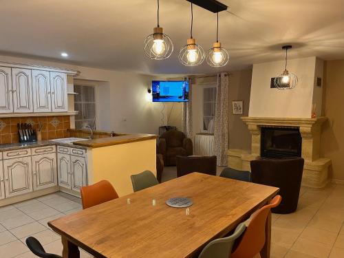 une cuisine et une salle à manger avec une table en bois et des chaises dans l'établissement Gîte famille Galiber, à Lacaune