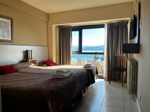 a hotel room with a bed and a large window at Hotel Internacional in San Carlos de Bariloche