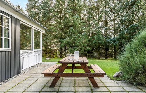 a wooden picnic table on a patio next to a house at Holiday Home Ildervej Hemmet Denmark in Hemmet