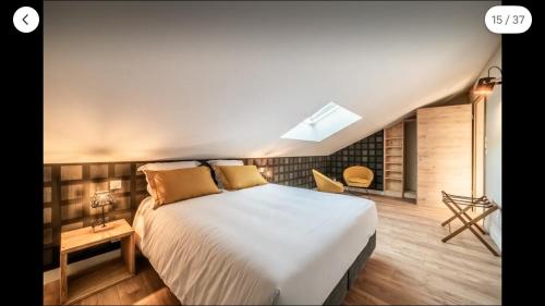 a bedroom with a large white bed and a table at Ô songes de Saxel in Saxel