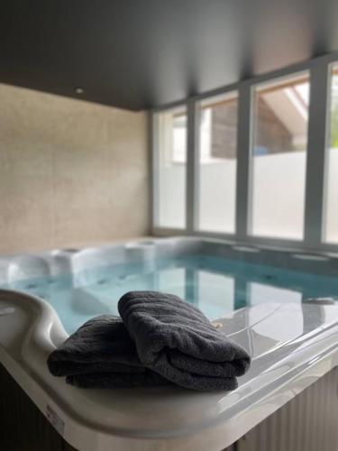 two towels are sitting on a table in front of a swimming pool at Ô songes de Saxel in Saxel