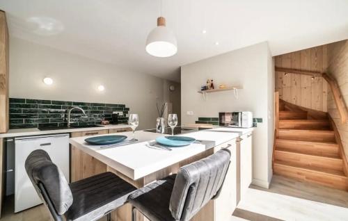 a kitchen with a counter with chairs and a sink at Ô songes de Saxel in Saxel