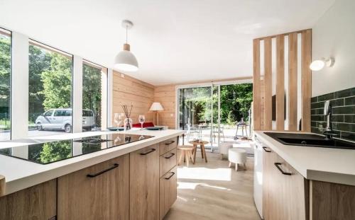a kitchen with wooden cabinets and a large window at Ô songes de Saxel in Saxel