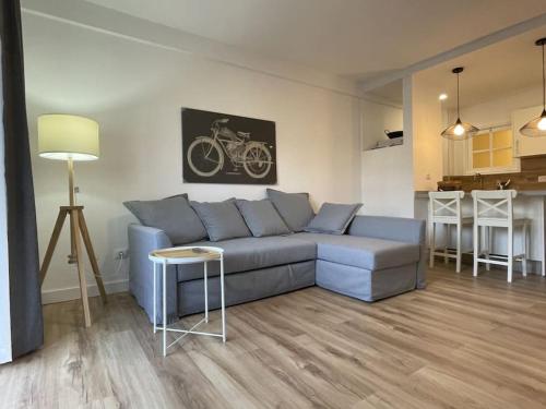 a living room with a blue couch and a kitchen at Apartamento en Tenerife - Alcalá - con vistas al Teide in Alcalá