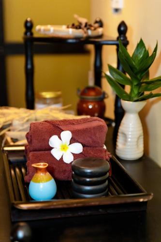 a tray with towels and a flower on a table at Sabina Boutique Hotel & Villa Mui Ne in Mui Ne