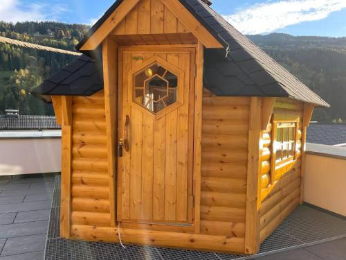 a wooden outhouse with a door on a roof at Sun Chalet in Schladming