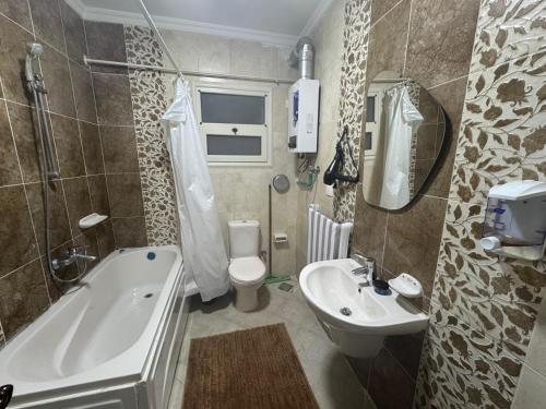Un baño con bañera, inodoro y lavabo. en Elegant Guest House, en New cairo