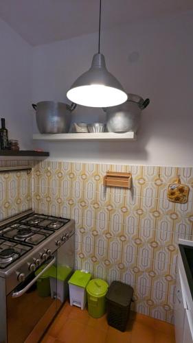 a kitchen with a stove and a pot on a shelf at Appartamento Nerium - Cala di Seta in Calasetta