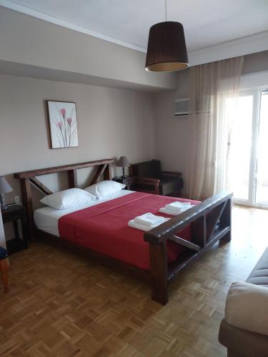 a bedroom with a bed with a red bedspread at Spyros Studio in Paleo Tsifliki