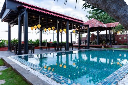 a swimming pool in front of a pavilion at Sabina Boutique Hotel & Villa Mui Ne in Mui Ne