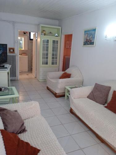 a living room with two couches and a tv at Villa Angela, Traditional Villa in the village in Agios Ioannis Peristeron
