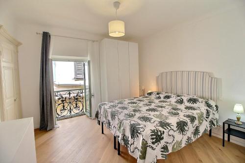 een slaapkamer met een bed met een zwart-witte deken bij B&B tra i tetti in Menton
