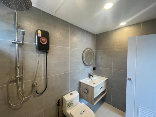 a bathroom with a shower and a toilet and a sink at Charming Condo in Sri Racha in Si Racha