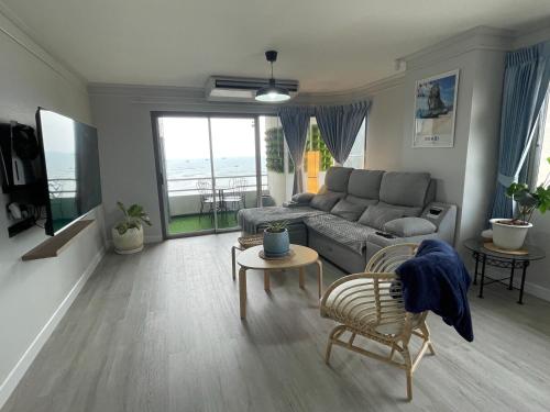 a living room with a couch and a table at Hot Deal ! Sea View Condo Cozy & Charming Si Racha in Si Racha
