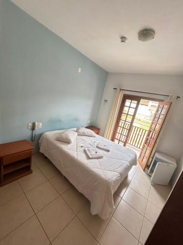 a bedroom with a bed and a large window at pousada Boa vista in Santo Antônio do Pinhal