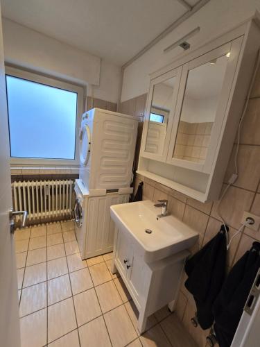 a white bathroom with a sink and a mirror at Ostwind in Damme