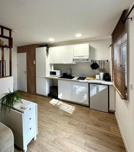 une cuisine avec des armoires blanches et un comptoir dans l'établissement Le Cocon de Montpellier - Hyper-Centre, Standing & Confortable, Full Équipé, à Montpellier