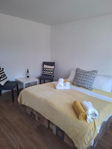 a bedroom with a large bed with two chairs at Sluneční villa Terezka Lednice ,penzion pro skupiny se snídaní,degustací vín in Lednice