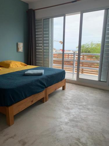 a bedroom with a bed and a large window at Casa Branca in Ponta do Sol