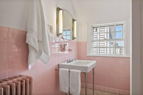 a pink bathroom with a sink and a mirror at Entire Historic Home in Portland West End in Portland