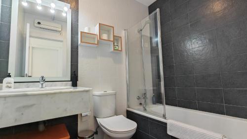 um banheiro com vaso sanitário, pia e banheira em Highest penthouse with best skyline & sea views em Benidorm