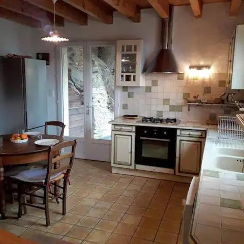 une cuisine avec une table et une cuisinière four supérieur dans l'établissement Gîte Canigou, à Jujols