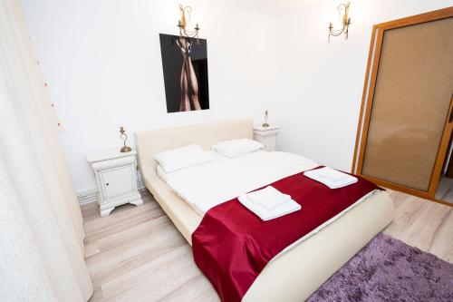 a bedroom with a large bed with a red blanket at Apartament Maria in Galaţi