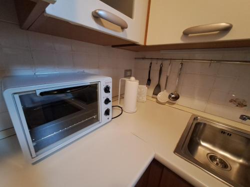 a white microwave on a counter in a kitchen at CASA BEA Elegante mansarda vicina a Fiera in Pero