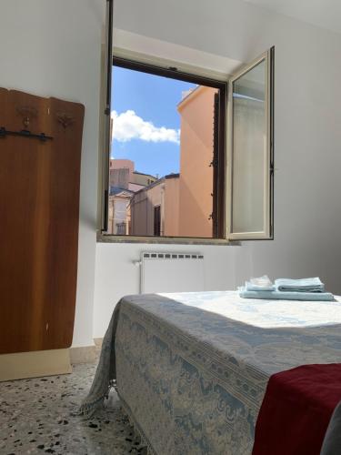 a bed in a room with a large window at Bed & Breakfast StudioArcodia- in San Marco dʼAlunzio