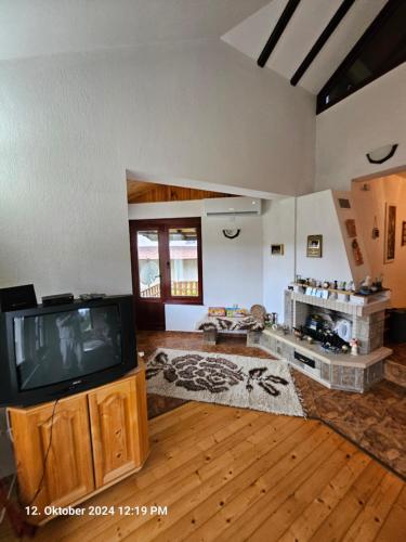 a living room with a tv on a wooden floor at Villa Dilyanka Stokite in Stoykite