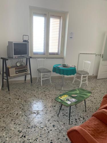 a living room with a couch and a table and a tv at Bed & Breakfast StudioArcodia- in San Marco dʼAlunzio