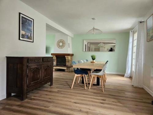 une salle à manger avec une table et des chaises en bois dans l'établissement Maison familiale Les 3 commères, à Pleuven