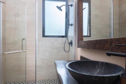 a bathroom with a sink and a glass shower at Increíble Villa 2 piscinas 4hab hasta 14 personas in Tulum