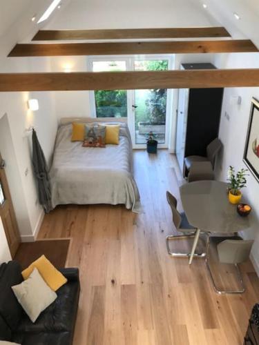 a bedroom with a bed and a table in a room at The Coach House, GUILDFORD in Guildford