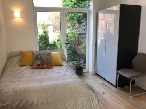 a bedroom with a bed and a sliding glass door at The Coach House, GUILDFORD in Guildford