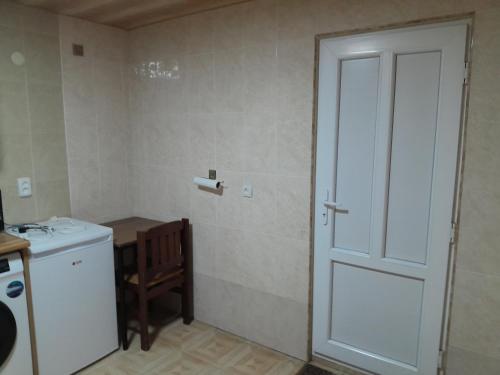 a bathroom with a door and a sink and a washing machine at Дом где ёсть всё удобства in Khashuri