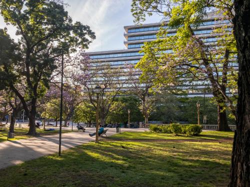 a park with a tall building in the background at Up Retiro in Buenos Aires