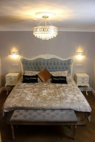 a bedroom with a large bed with a blue headboard at Milestone Cottage in Swansea