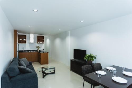 una sala de estar con un sofá y una mesa en The One Apartment, en Rawai Beach